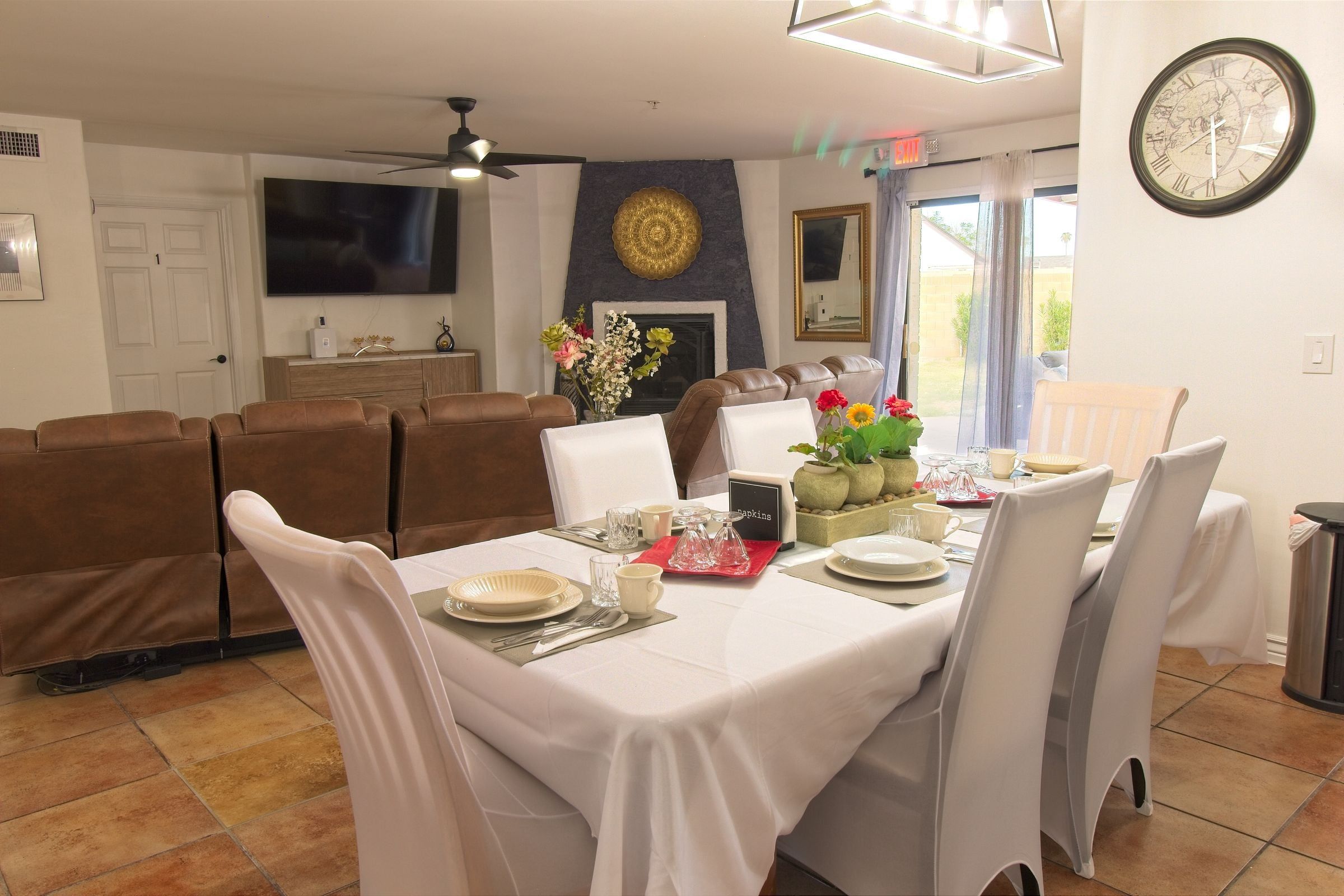 The dining table set for a meal, with the living room and fireplace beyond
